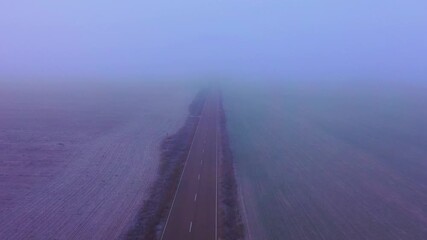 Fast Drone Flight Above Rural Road Highlighting Poor Visibility in Winter Fog