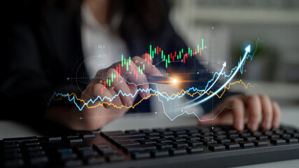 A business professional works on a keyboard while analyzing dynamic financial graphs, highlighting growth trends and data indicators in a modern office setting. Scalp