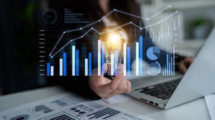 A business professional holds a light bulb symbolizing innovation, while analytic graphs and data charts illustrate growth strategies in a digital workspace. Scalp
