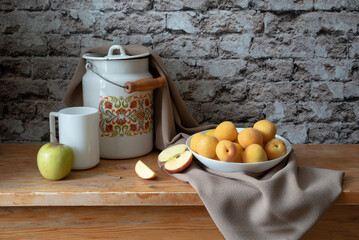 Still life with a plate of apricots, a can, and a glass in yellow and orange tones