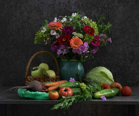On the table there are vegetables, fruits, ready to eat and prepare tasty and healthy food, and a luxurious bouquet of flowers