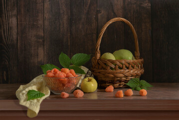 A delicious still life with orange raspberries and green apples in a basket
