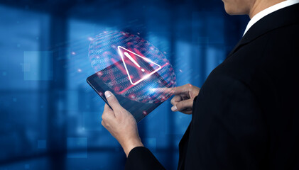 A businessman interacts with a digital tablet showcasing an alert symbol and binary code, highlighting technology and security in a modern office setting. Gantry