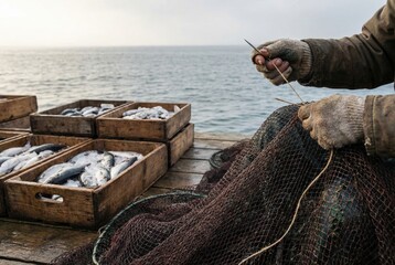 Fisherman mending a net while preparing catch for sale at the harbor in the early morning light near the sea