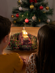 Children near a Christmas Yule cake with candles