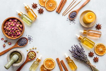 Aromatic natural ingredients for skincare and wellness products, including essential oils, herbs, spices, and botanicals arranged in a circle on a white surface, evoking.