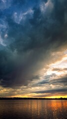 Storm clouds over sunset lake