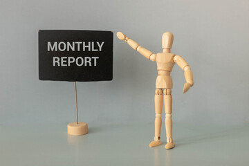 open notebook on a wooden table. glasses and a calculator. words monthly report