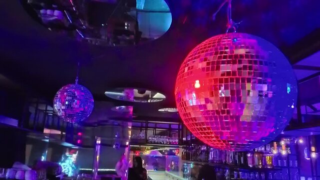 Sofia, Bulgaria - 12.31.2025. Shining bright disco ball in neon pink lighting in dance night club night party.