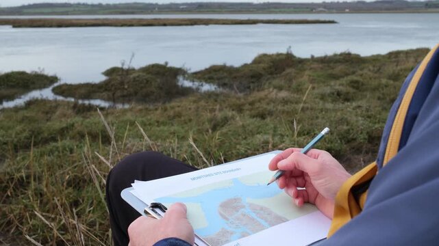 Scientist Monitoring Coastal Habitat and Sea Level Rises on Site Boundary Map on Clipboard