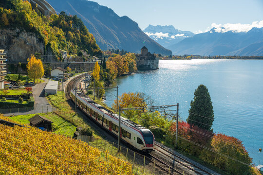 Train passing Chillon Castle on Lake Geneva shore. Veytaux, Canton of Vaud, Switzerland.