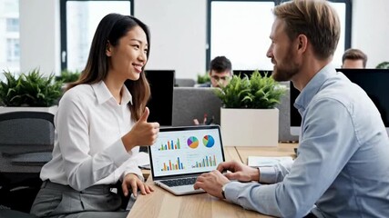 Businesswoman explaining data on laptop to businessman in modern office - Powered by Adobe