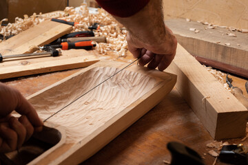 The master measures the size of the soundboard on the billet for the talharpa