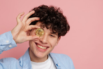Smiling young man holding crypto coin over eye digital finance blockchain and trading concept