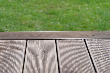 Empty rustic table top with blurred green grass landscape background. Abstract wooden counter. Mockup for promo, text or logo brand. Free space for text. Frame for display. Modern Presentation desk.