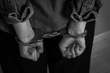 Handcuffed woman, closeup. Captured criminal. Black and white toning