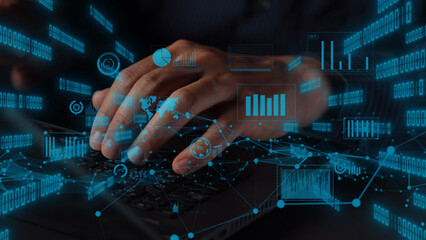 Close-up view of hands typing on a laptop surrounded by digital graphs and data elements, representing modern analytics and technology trends in a dynamic workspace. Xenic