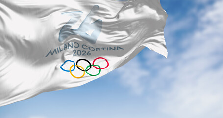 Fototapeta premium Milano Cortina 2026 Winter Olympic Games Flag Waving Blue Sky