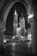 Czarno-białe zdjęcie Rynku Głównego w Krakowie, ukazujące historyczną architekturę, brukowane ulice i atmosferę zabytkowego centrum miasta.  © BMC