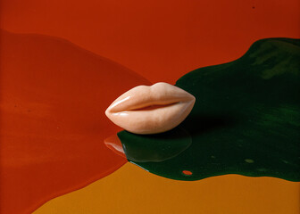 Shea butter in the shape of female lips against a background of oil splashes
