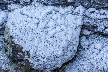 Close-up of dense, needle-like ice crystals (hoarfrost) covering a rock.