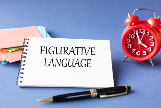 FIGURATIVE LANGUAGE - words in notebook on blue background with watch and pen
