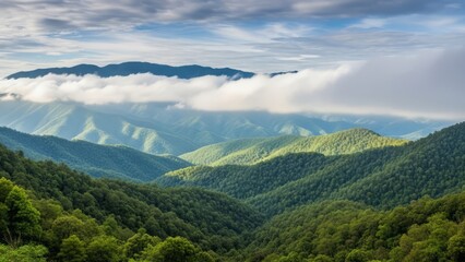 Fototapeta premium Rolling hills and mountains shrouded in mist and clouds under a blue sky