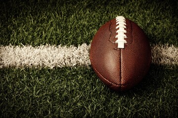 Obraz premium American football on green turf close up view of a professional game ball