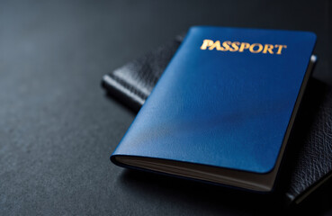 Blue passport rests on a dark textured surface, evoking travel and identity