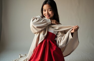 Naklejka premium Girl wearing a red dress and oversized beige coat smiling at the camera
