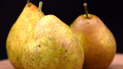 Fresh pears with water droplets on a dark background