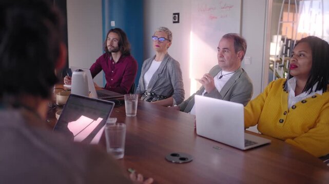 Diverse Team of Professional Business people Meeting in the Office Conference Room. Creative Team Around Table, colleagues Speak for Marketing Campaign, Social Media Strategy. Modern Workplace