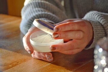 A box of snus pads in the girl's hands replaces smokeless cigarettes.