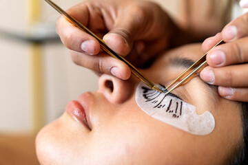 Lash artist applying false eyelashes on client