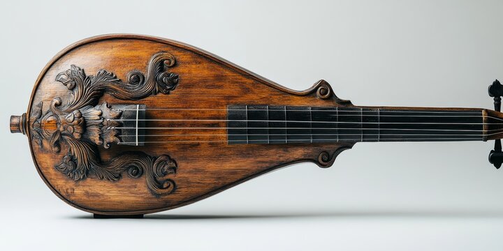 Baroque cittern or lute musical instrument with ornate carvings lying on white background