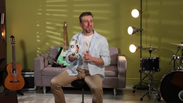 Man playing tambourine at home. Musical instrument
