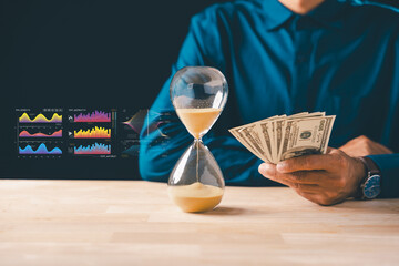 Person holds money banknotes, hourglass shows time, business investment strategy with global finance data charts, planning saving and wealth growth for deposit bank concept