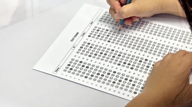 Education concept, close up of hand writing on test paper. University admission or final exam assessment concept.