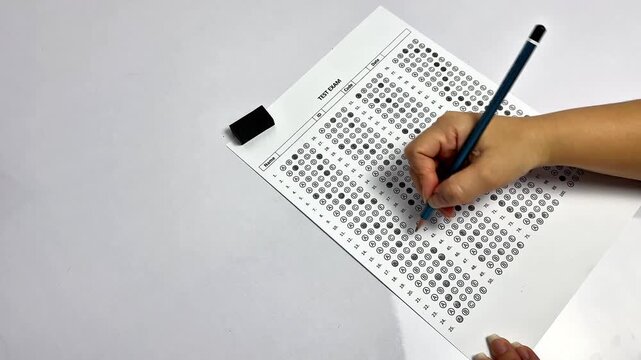 Education concept, close up of hand writing on test paper. University admission or final exam assessment concept.