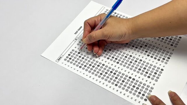 Education concept, close up of hand writing on test paper. University admission or final exam assessment concept.