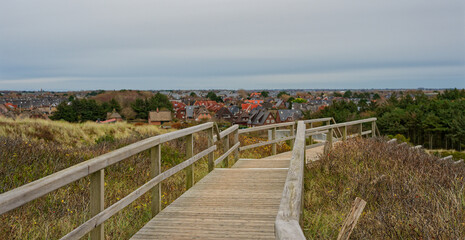 Fototapeta premium Valley houses and wooden path toward Sylt sea beach