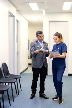 Doctor and nurse talking while walking on the hallway