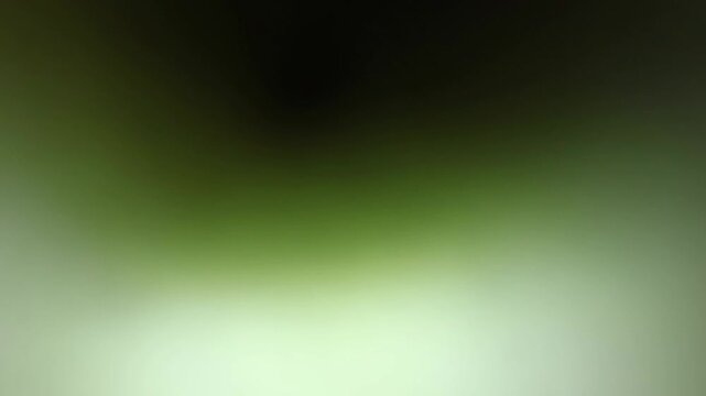 Una toma de cerca de un fondo abstracto de color verde con negro un degradado ligero desenfocado en movimiento