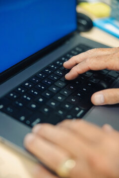 Close-up view of hands actively typing on a laptop keyboard