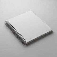 Blank spiral bound notepad rests diagonally on a light gray surface