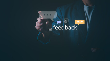 Businessman touching feedback icon with chat bubbles and star rating on dark background, Concept of customer satisfaction survey, user experience, online review, and service evaluation.