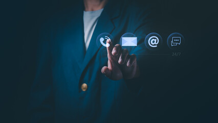 Businessman touching channel contact icons on virtual screen. Concept of Twenty-four seven customer service, technical support, communication center, global helpline, and business connectivity.