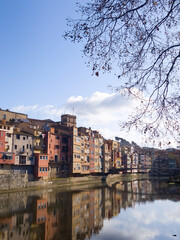Fototapeta premium Colorful riverside houses reflected on calm water under blue sky, European old town cityscape with vibrant architecture, travel destination and urban landscape background