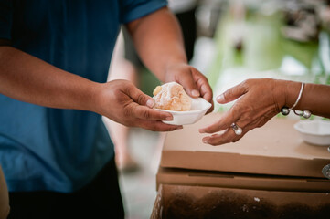 The hands of the hungry are asking for food from the donor