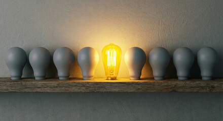 Glowing lightbulb standing out from row of grey bulbs